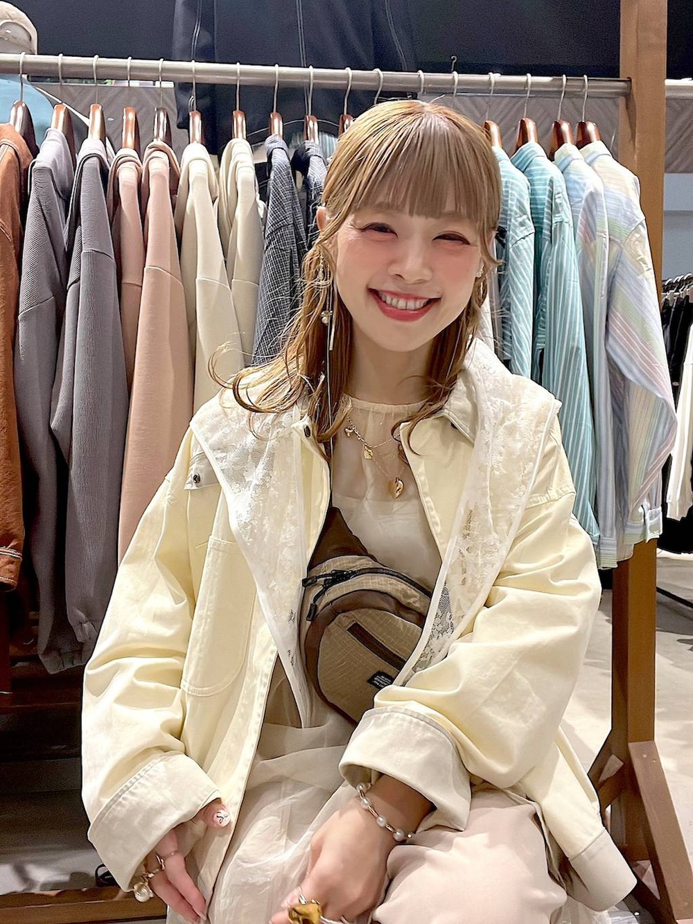 ホワイト系のベスト、ベージュ系のボディバッグ/ウエストポーチ、ホワイト系のブルゾンを着用したレディースの春コーディネートの9枚目の写真