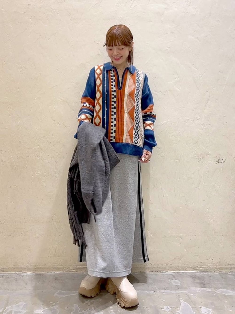 ブルー系のニット/セーター、グレー系のストール/ショール、ブラック系のバレッタ/ヘアクリップを着用したレディースの秋コーディネートの4枚目の写真