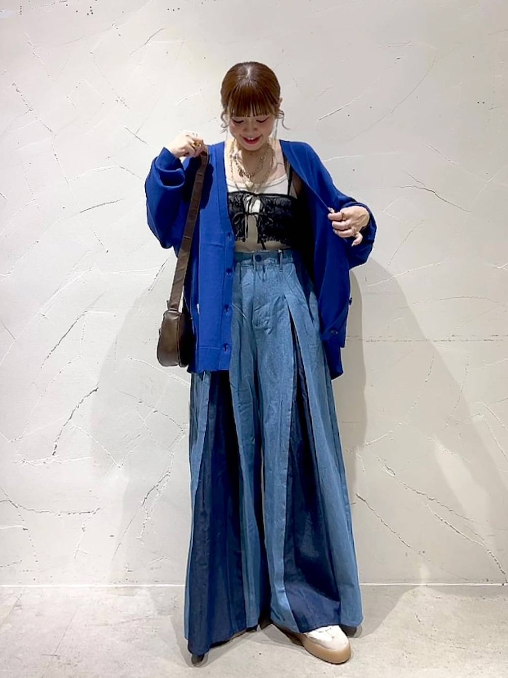 ブラック系のキャミソール、ブラウン系のショルダーバッグを着用したレディースの秋コーディネートの3枚目の写真