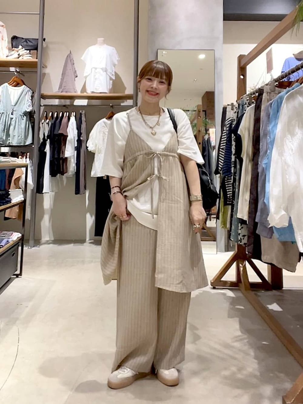 ブラック系のショルダーバッグ、ホワイト系のTシャツ/カットソー、ベージュ系のその他雑貨を着用したレディースの夏コーディネートの9枚目の写真