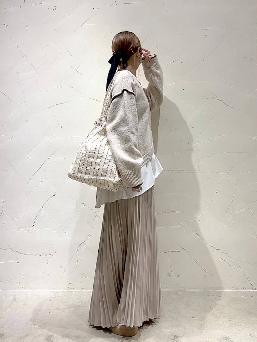 ベージュ系のスカート、その他のトートバッグ、ゴールド系のネックレスを着用したレディースの秋コーディネートの3枚目の写真