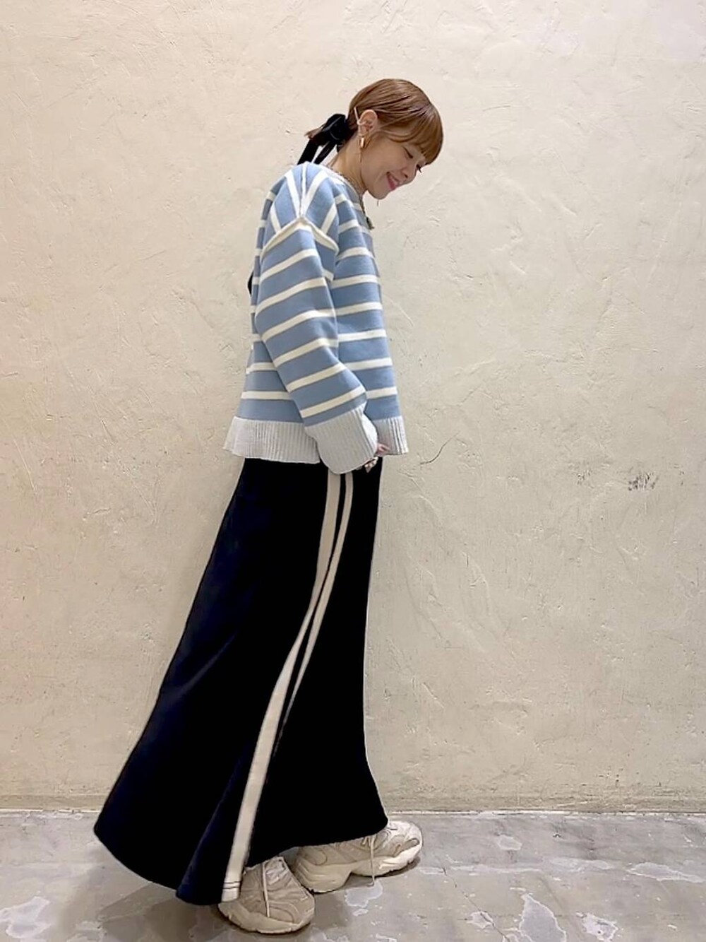 ホワイト系のTシャツ/カットソー、ブラック系のスカート、ベージュ系のニット/セーターを着用したレディースの冬コーディネートの4枚目の写真