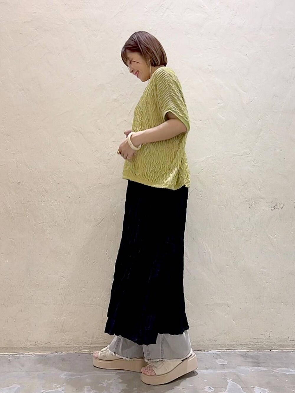 ホワイト系のサンダル、ブラック系のスカート、グレー系のデニムパンツを着用したレディースの夏コーディネートの5枚目の写真