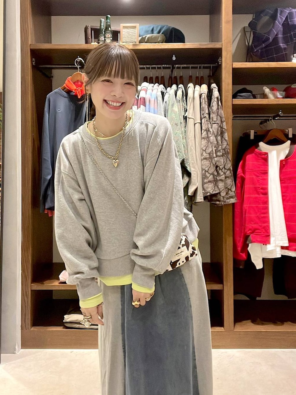 ベージュ系のパンプス、グレー系のスウェット、ブルー系のデニムスカートを着用したレディースの秋コーディネートの8枚目の写真