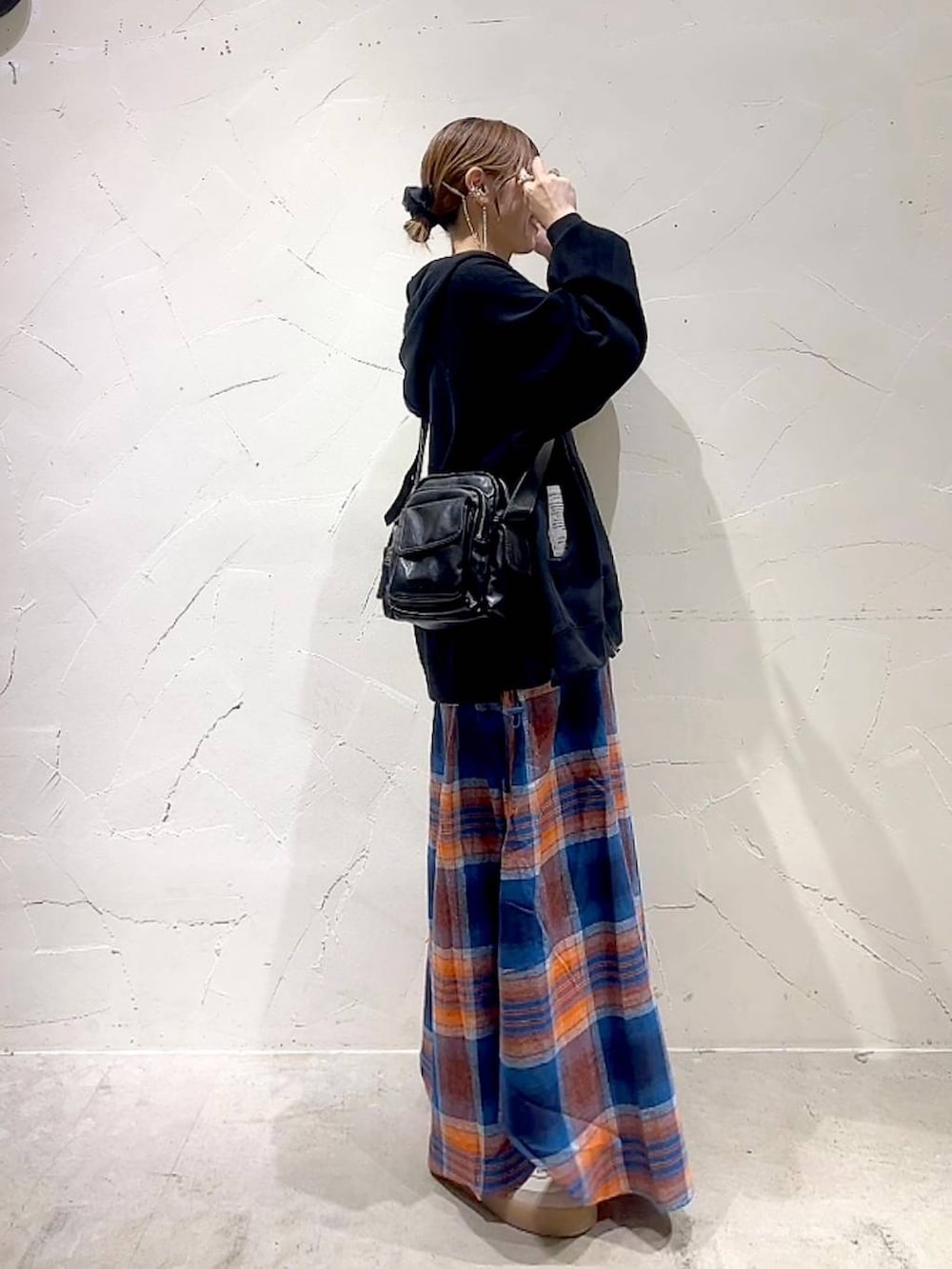 ブラック系のショルダーバッグ、イエロー系のネックレスを着用したレディースの秋コーディネートの4枚目の写真