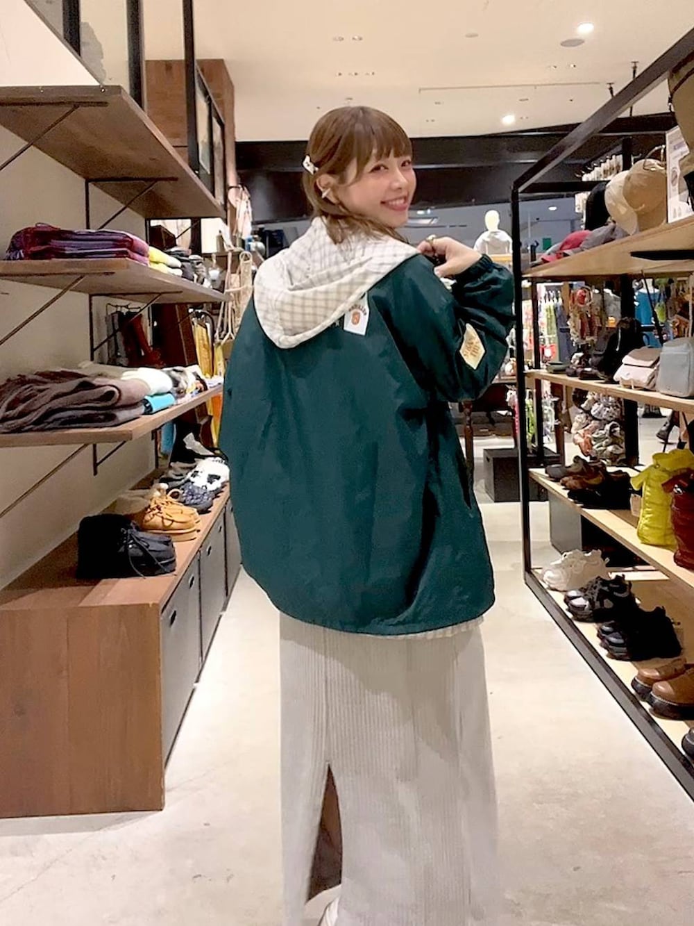 グレー系のスカート、ベージュ系のシャツ/ブラウス、グリーン系のナイロンジャケットを着用したレディースの冬コーディネートの4枚目の写真