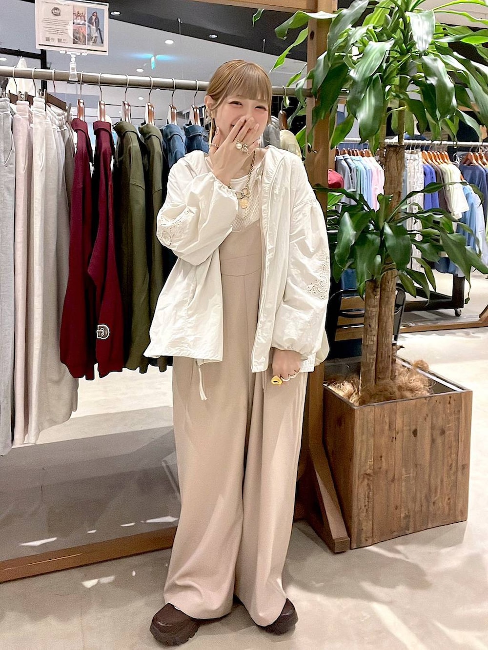 ベージュ系のブルゾン、ブラウン系のスニーカー、ホワイト系のTシャツ/カットソーを着用したレディースの春コーディネートの2枚目の写真