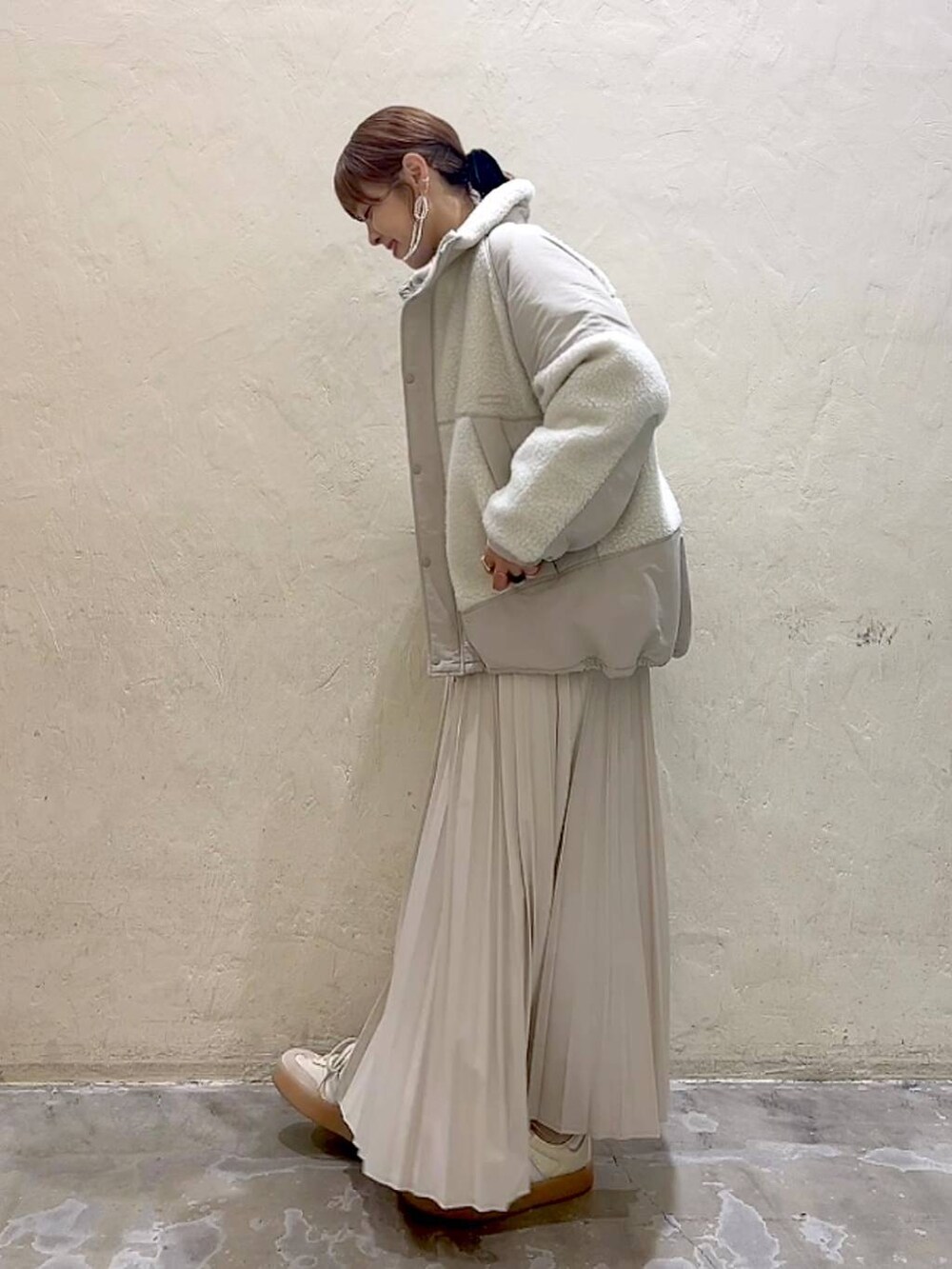 ベージュ系のスカート、ベージュ系のブルゾン、グレー系のニット/セーターを着用したレディースの秋コーディネートの5枚目の写真