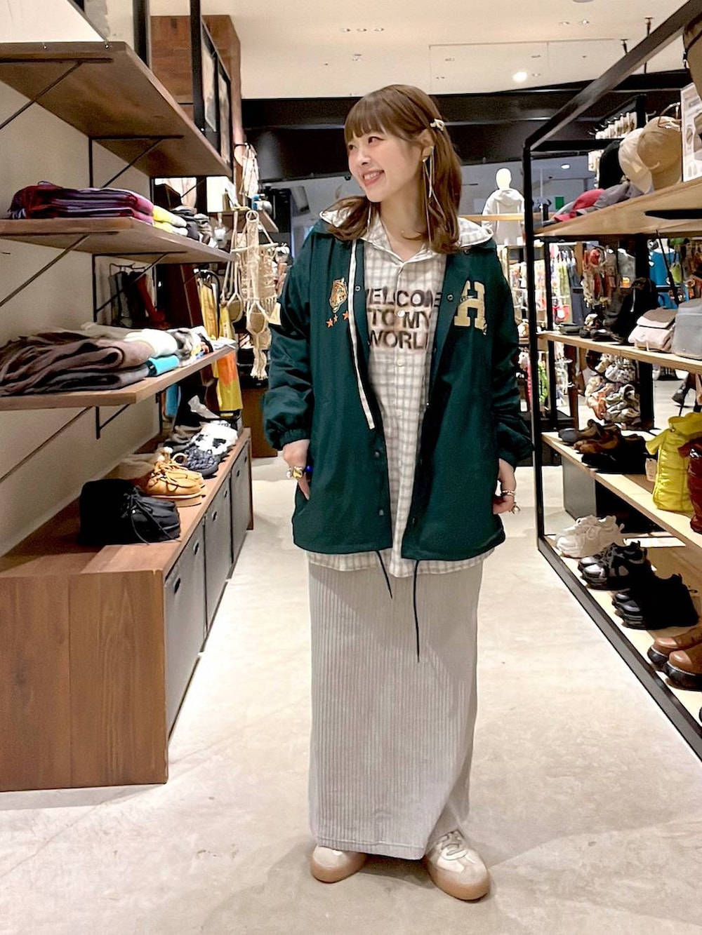 グレー系のスカート、ベージュ系のシャツ/ブラウス、グリーン系のナイロンジャケットを着用したレディースの冬コーディネートの5枚目の写真