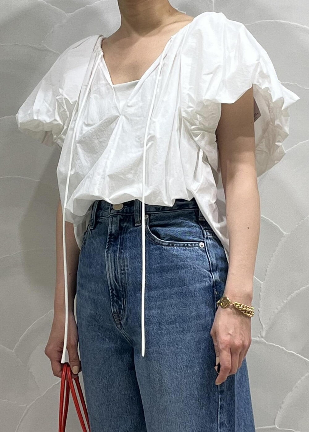 ブルー系のデニムパンツ、ホワイト系のシャツ/ブラウス、ホワイト系のキャミソールを着用したレディースの春コーディネートの3枚目の写真