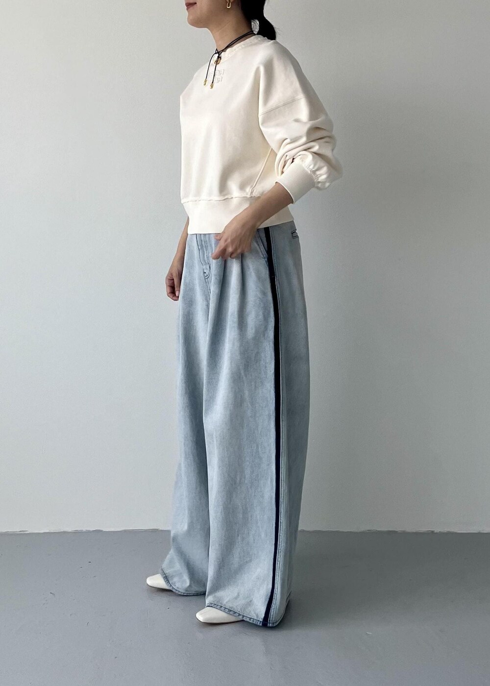 ホワイト系のブーツ、ブルー系のその他パンツ、ホワイト系のスウェットを着用したレディースの秋コーディネートの3枚目の写真