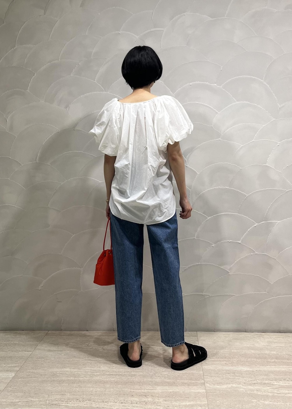 ブルー系のデニムパンツ、ホワイト系のシャツ/ブラウス、ホワイト系のキャミソールを着用したレディースの春コーディネートの2枚目の写真