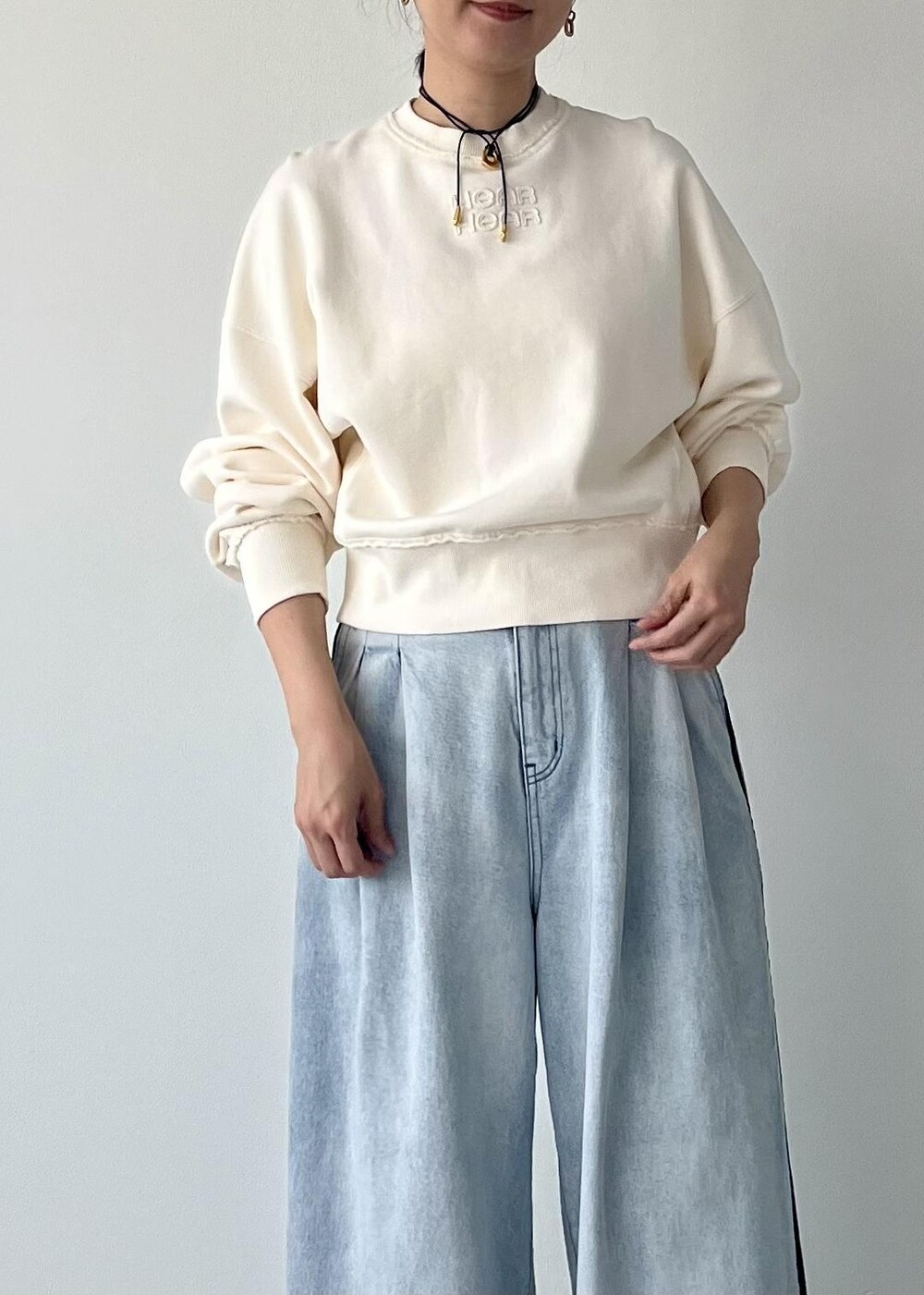 ホワイト系のブーツ、ブルー系のその他パンツ、ホワイト系のスウェットを着用したレディースの秋コーディネートの4枚目の写真