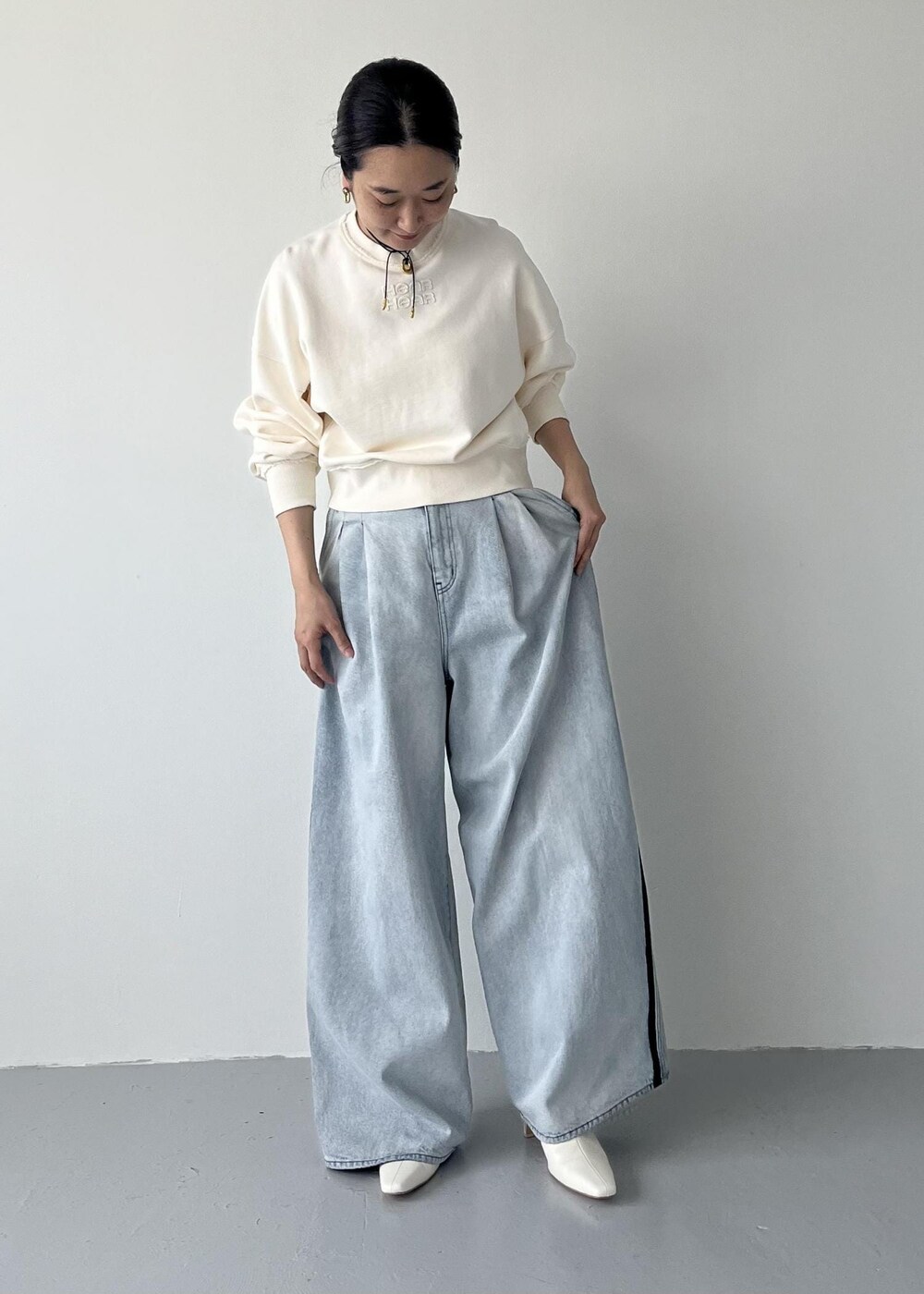 ホワイト系のブーツ、ブルー系のその他パンツ、ホワイト系のスウェットを着用したレディースの秋コーディネートの2枚目の写真