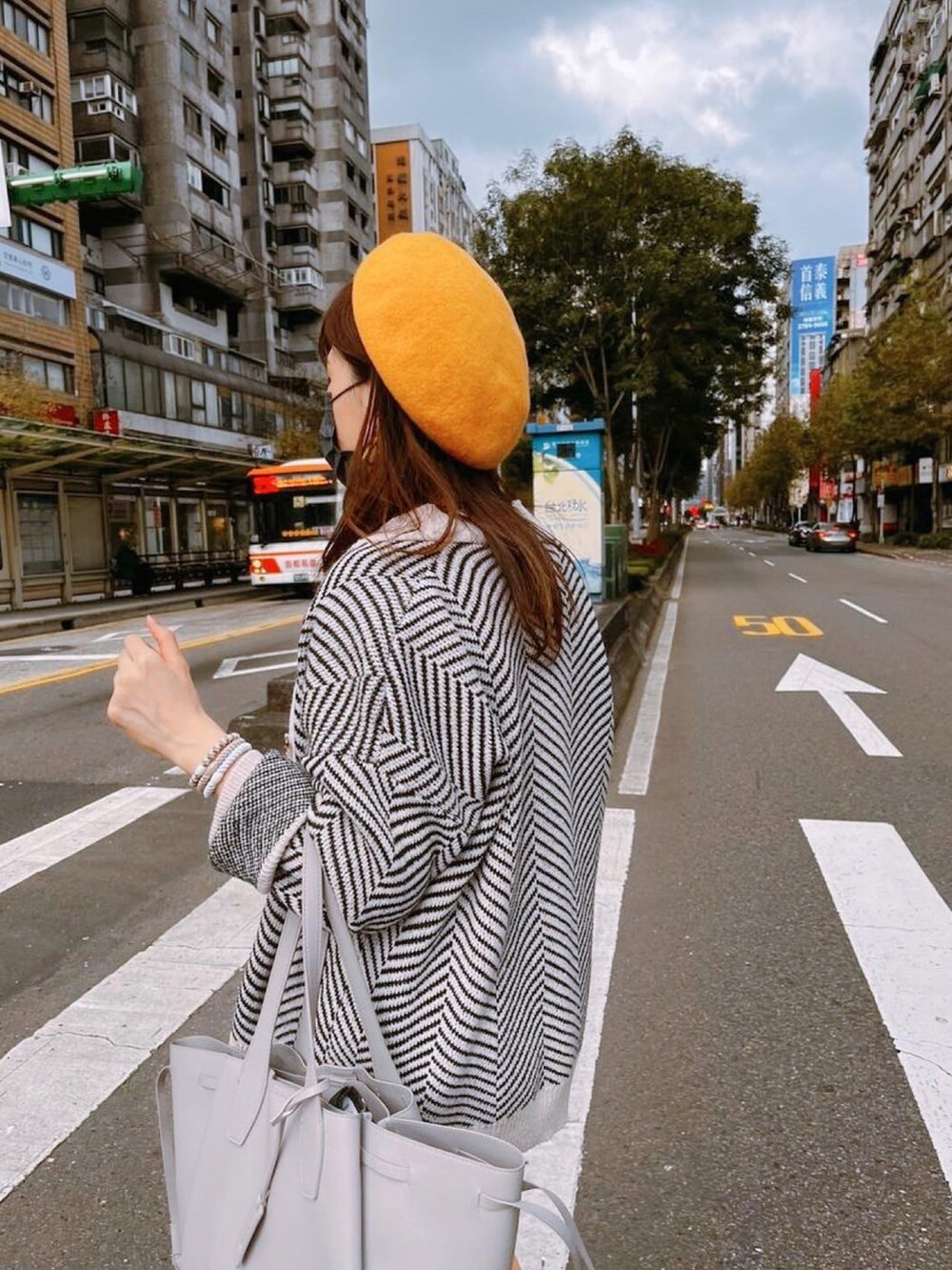 イエロー系のチノパンツ、ベージュ系のその他トップス、グレー系のトートバッグを着用したレディースの冬コーディネートの5枚目の写真