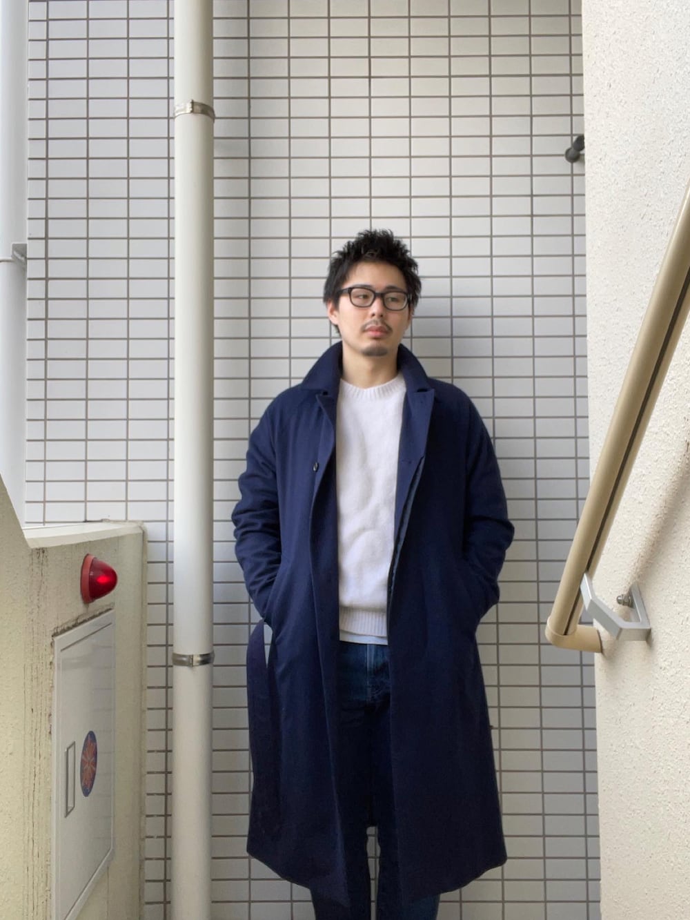 ホワイト系のニット/セーター、ブルー系のトレンチコート、ブラウン系のシューズを着用したメンズの秋コーディネートの2枚目の写真