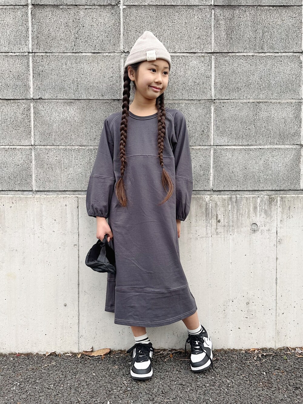グレー系のワンピース、ブラック系のボディバッグ/ウエストポーチ、ブラック系のスニーカーを着用したキッズの春コーディネートの2枚目の写真