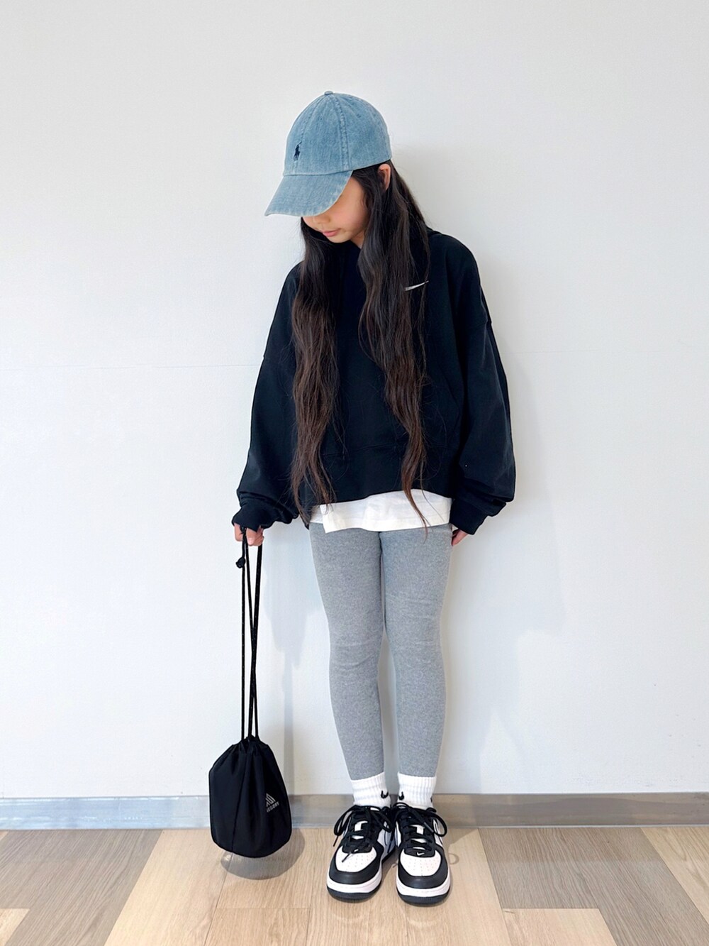ブラック系のパーカー、ホワイト系のTシャツ/カットソー、ブラック系のショルダーバッグを着用したキッズの春コーディネートの2枚目の写真