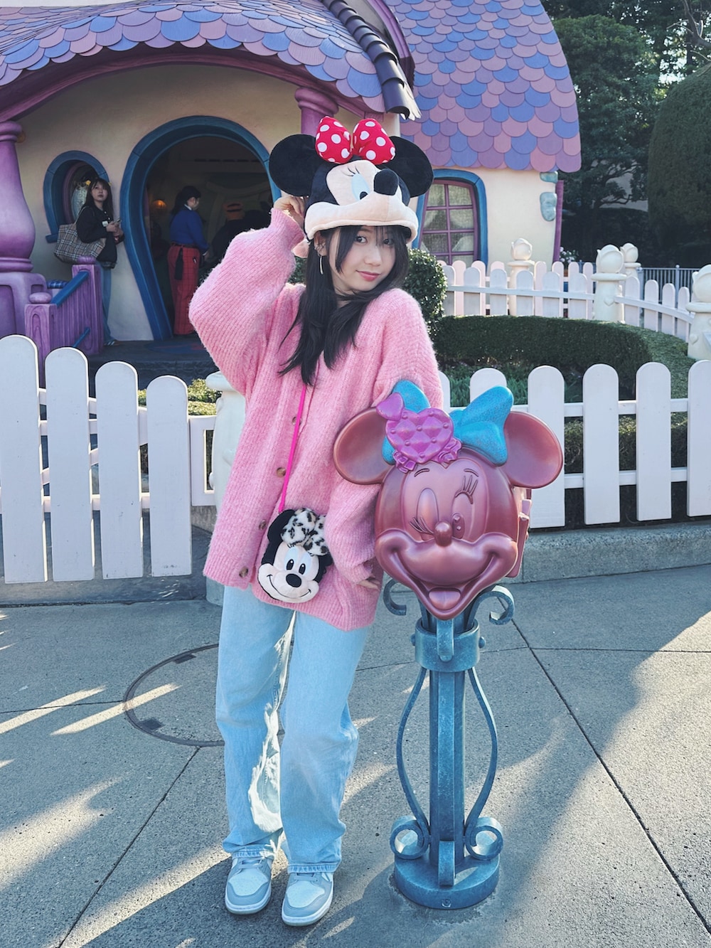 ピンク系のカーディガン/ボレロ、ブルー系のデニムパンツ、グレー系のスニーカーを着用したキッズの春コーディネートの2枚目の写真