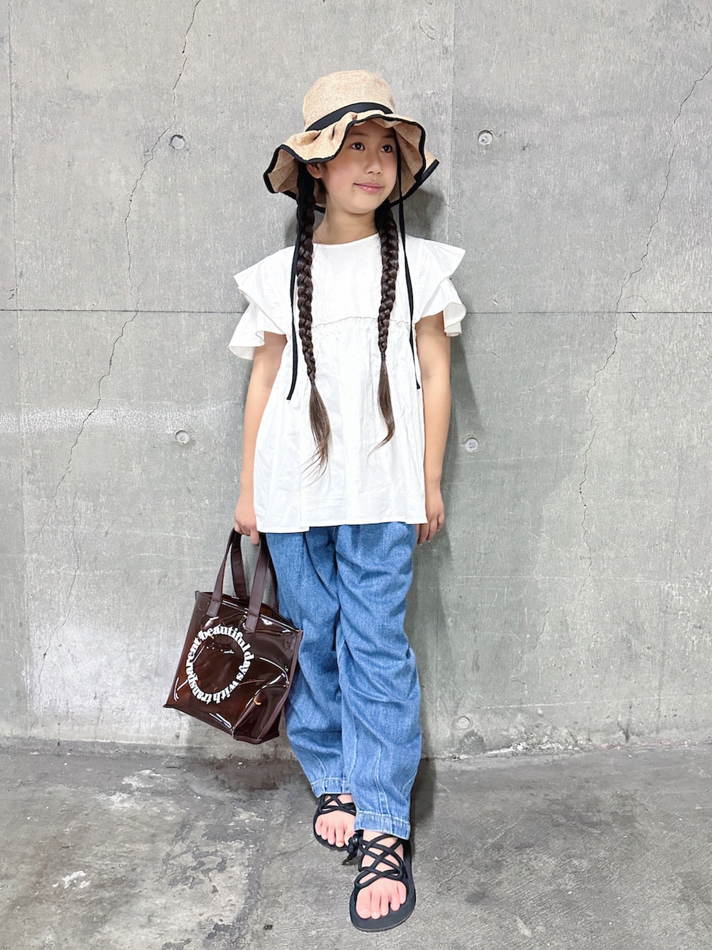 ホワイト系のTシャツ/カットソー、ブルー系のデニムパンツ、ブラック系のサンダルを着用したキッズの夏コーディネートの2枚目の写真