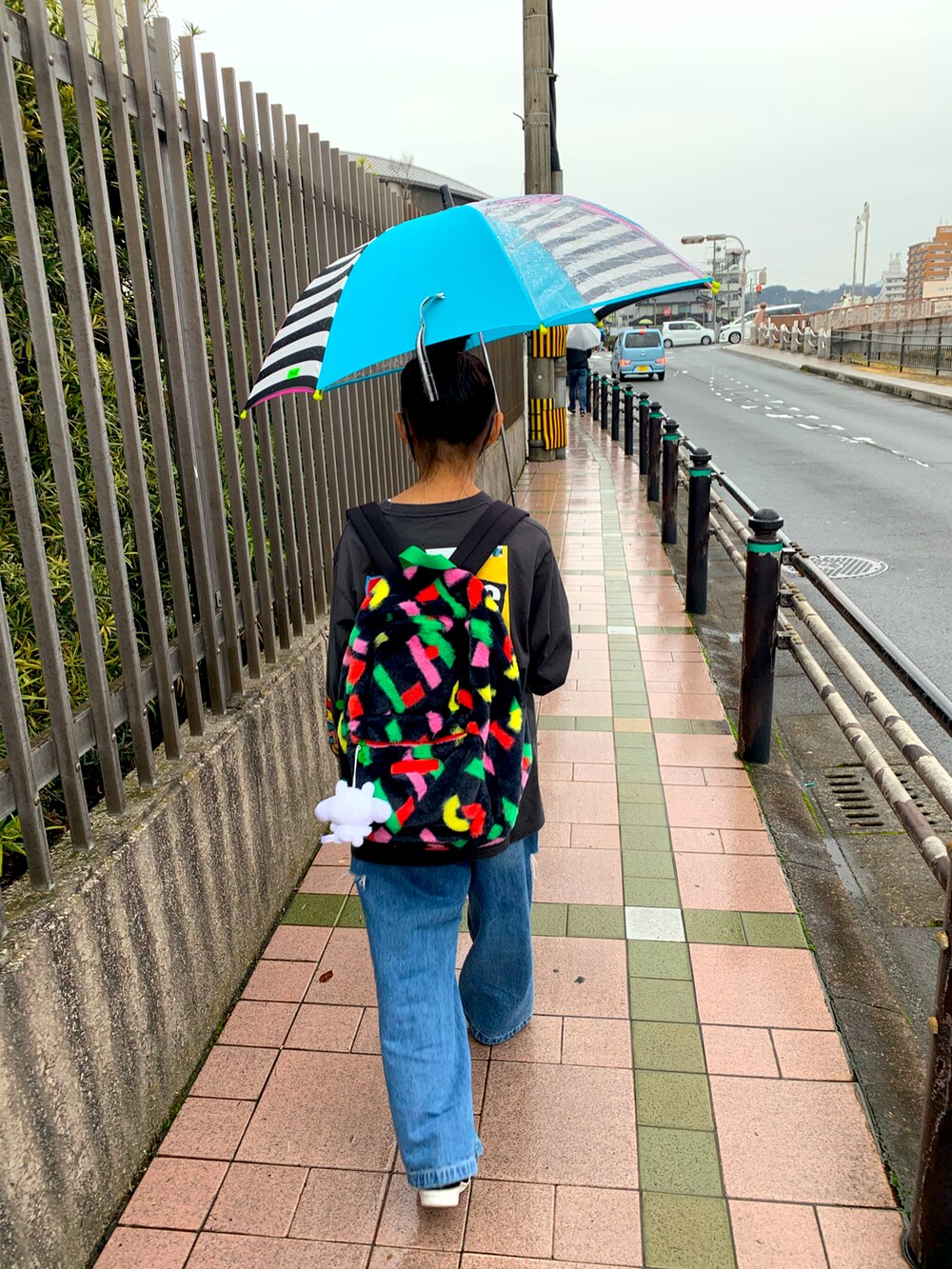 ブラック系のバックパック/リュック、ブラック系のTシャツ/カットソー、ブルー系のデニムパンツを着用したキッズの冬コーディネートの2枚目の写真