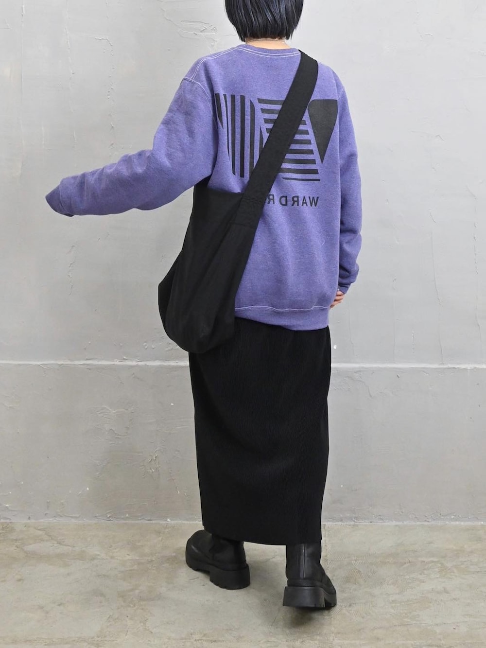 パープル系のスウェット、ブラック系のショルダーバッグ、ブラック系のスカートを着用したレディースの冬コーディネートの2枚目の写真