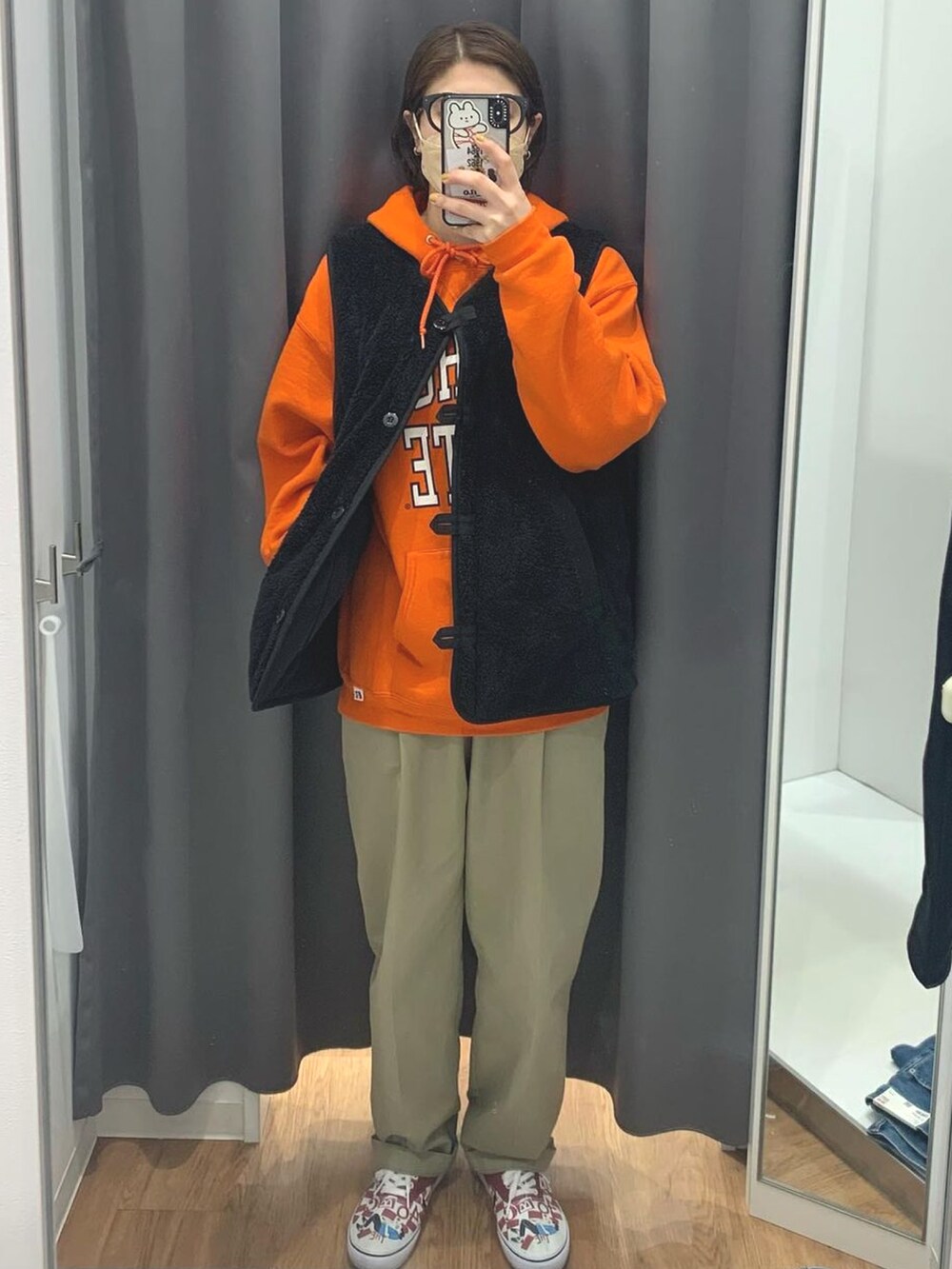 ブラック系のベスト、ベージュ系のチノパンツ、その他のスニーカーを着用したレディースの夏コーディネートの2枚目の写真