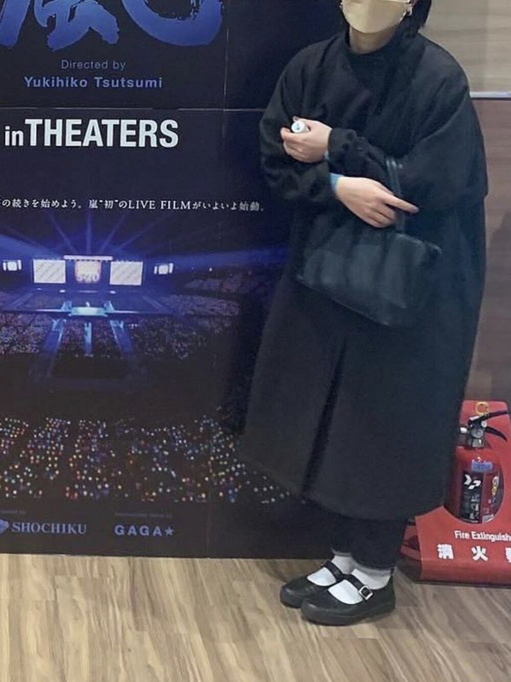 ブラウン系のステンカラーコートを着用したレディースの冬コーディネートの2枚目の写真