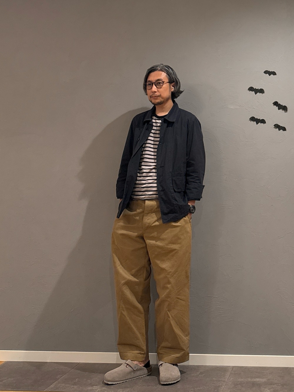 ブラック系のスニーカー、グレー系のTシャツ/カットソー、ブルー系のカバーオールを着用したメンズの秋コーディネートの2枚目の写真