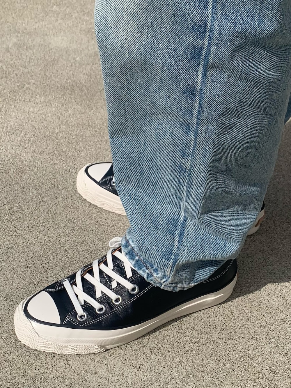 ブラック系のスニーカー、ブルー系のデニムパンツ、グリーン系のミリタリージャケットを着用したメンズの冬コーディネートの2枚目の写真