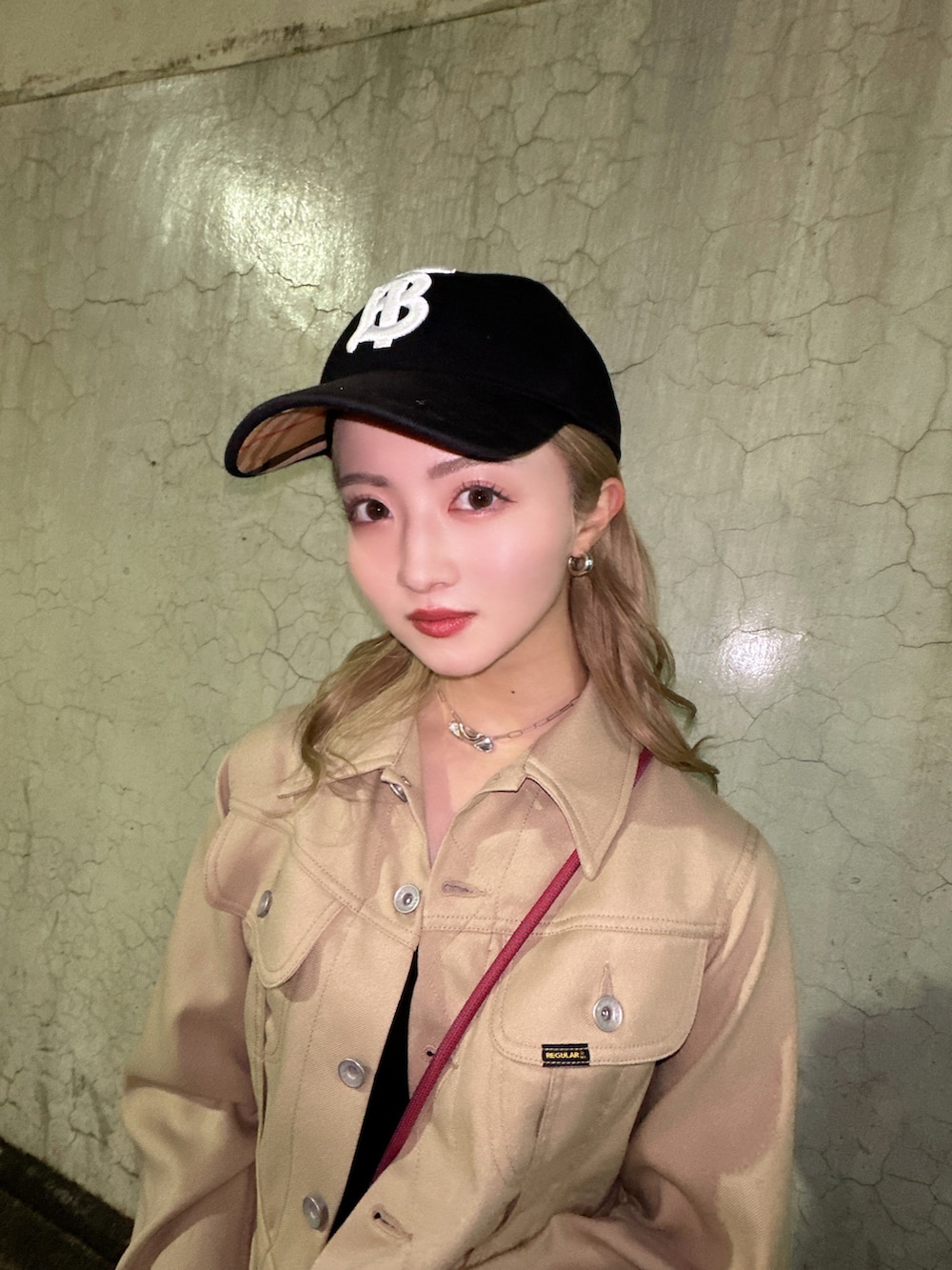 ベージュ系のその他アウター、ベージュ系のスカート、ブラック系のブーツを着用したレディースの春コーディネートの2枚目の写真