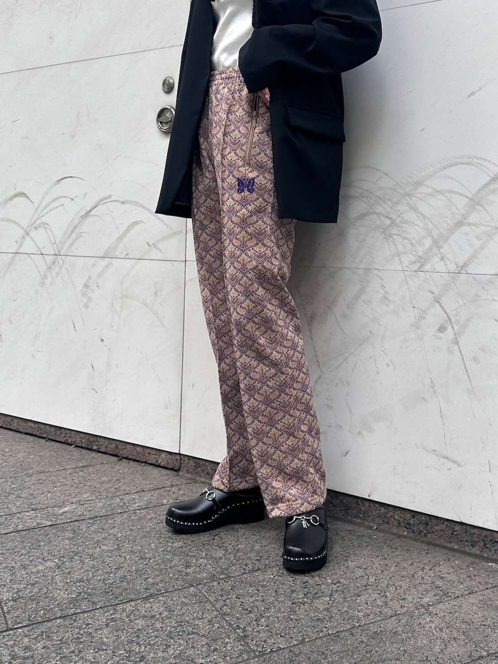 ブラウン系のパンツ、ホワイト系のタンクトップ、ブラック系のジャケット/アウターを着用したレディースの春コーディネートの3枚目の写真