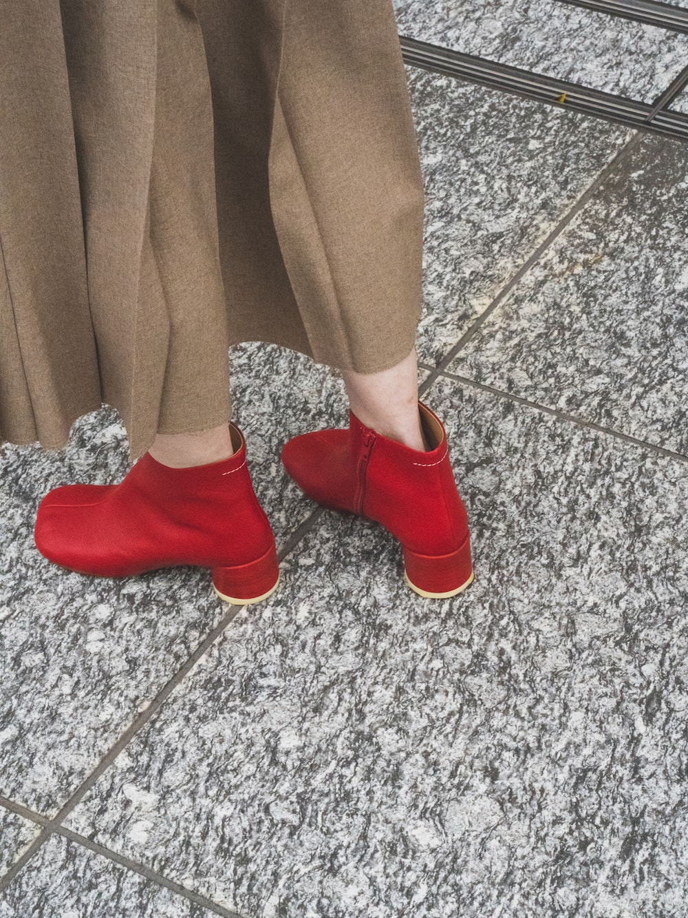 ベージュ系のスカート、ブルー系のデニムジャケット、ブラック系のハンドバッグを着用したレディースの春コーディネートの5枚目の写真