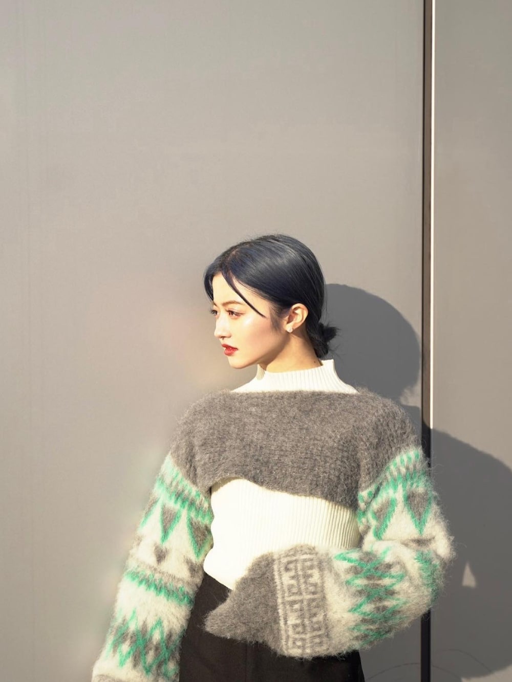 グレー系のニット/セーター、ブラック系のパンツ、ブラック系のブーツを着用したレディースの冬コーディネートの2枚目の写真