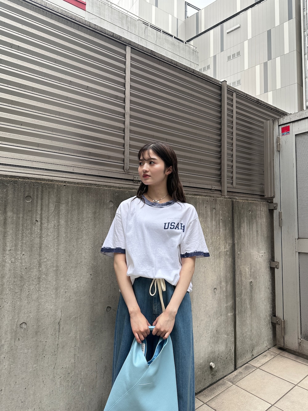 ホワイト系のTシャツ/カットソー、ブルー系のデニムパンツ、ブルー系のハンドバッグを着用したレディースの夏コーディネートの2枚目の写真
