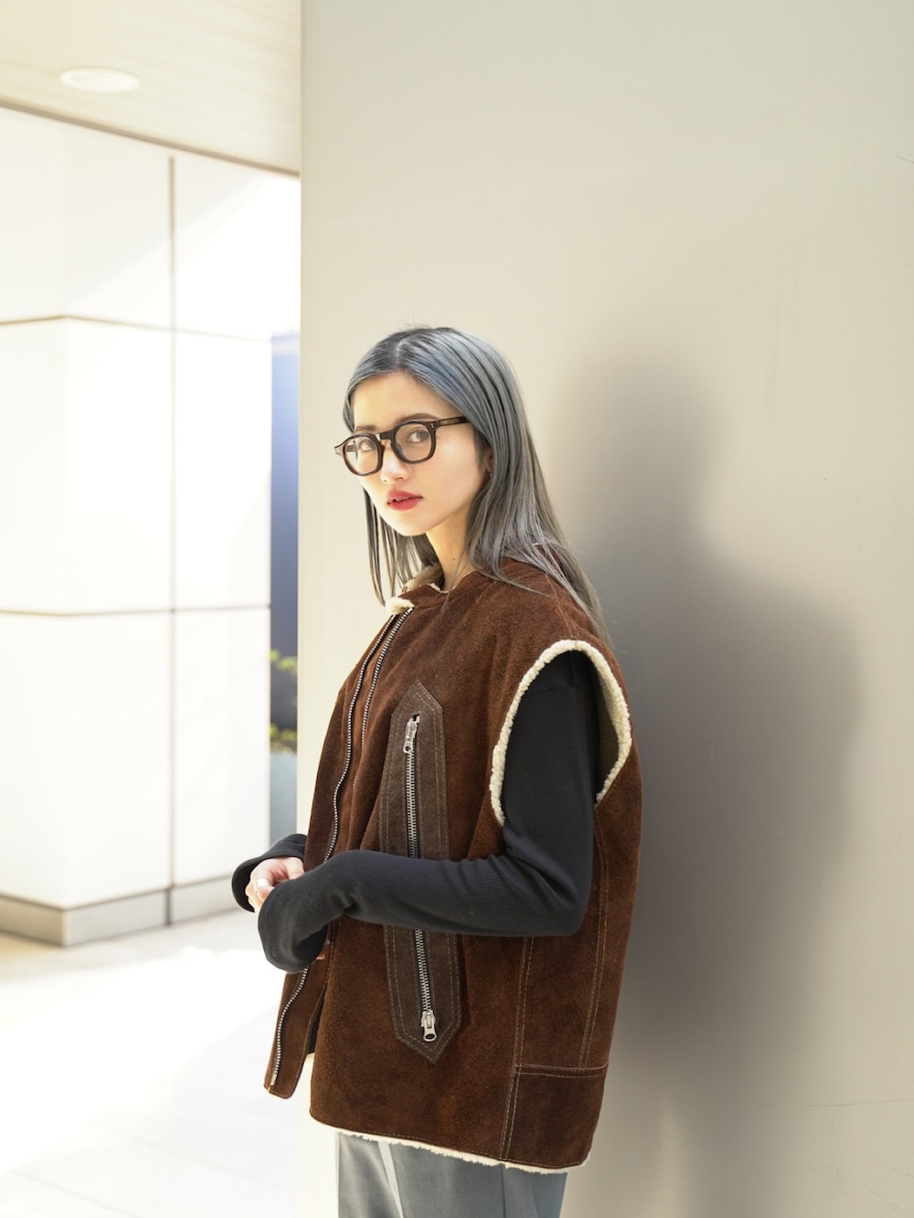 ブラウン系のベスト、グレー系のスラックス、ホワイト系のローファーを着用したレディースの冬コーディネートの2枚目の写真