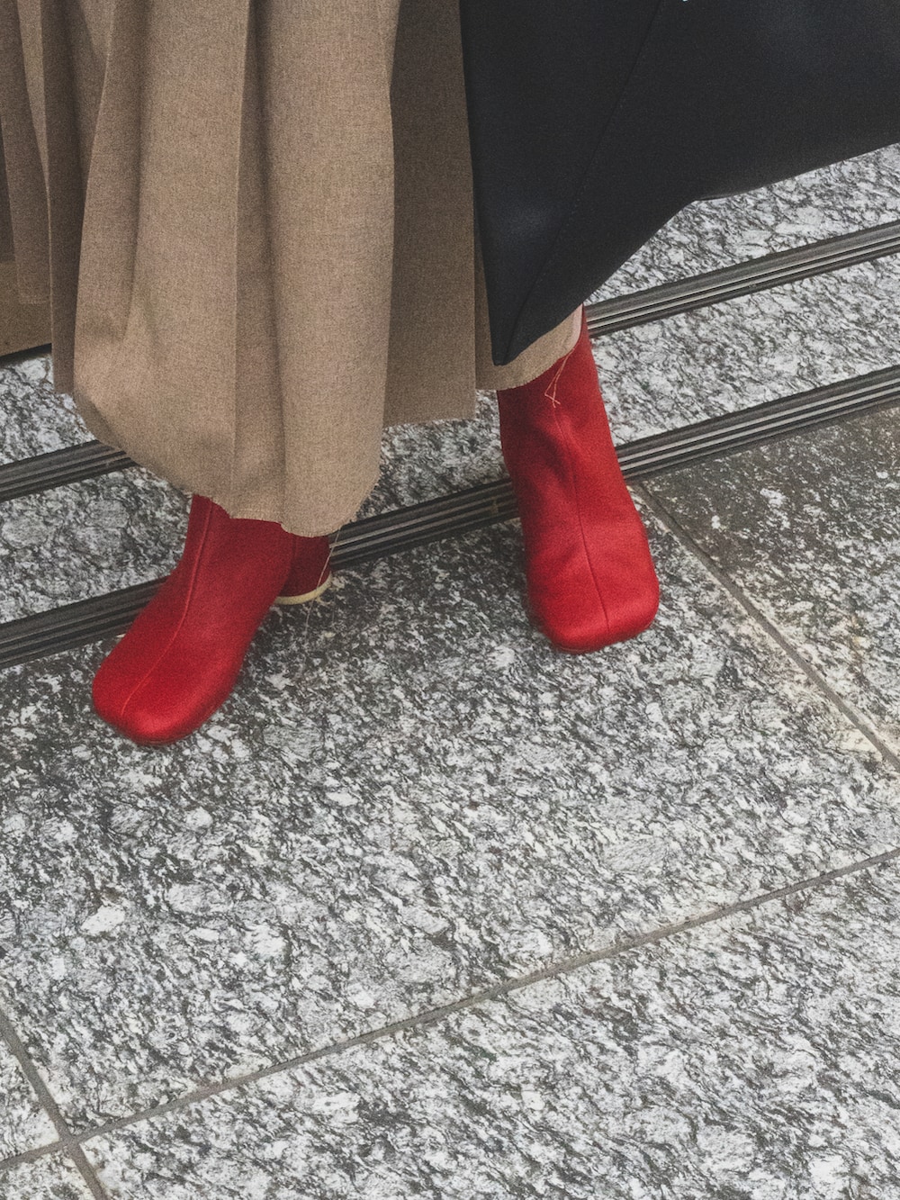 ベージュ系のスカート、ブルー系のデニムジャケット、ブラック系のハンドバッグを着用したレディースの春コーディネートの4枚目の写真