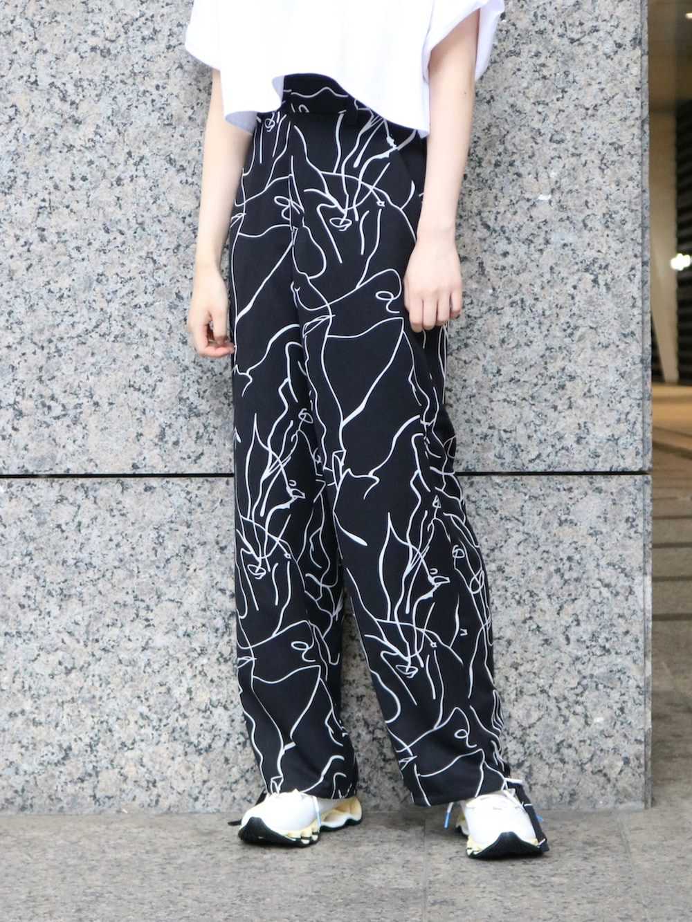 ホワイト系のTシャツ/カットソー、ブラック系のその他パンツ、ホワイト系のスニーカーを着用したレディースの夏コーディネートの3枚目の写真