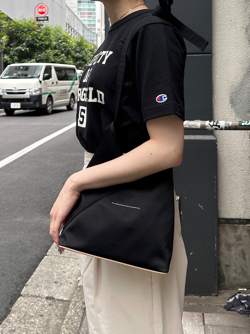 ブラック系のショルダーバッグ、ブラック系のTシャツ/カットソー、ホワイト系のその他パンツを着用したレディースの夏コーディネートの2枚目の写真