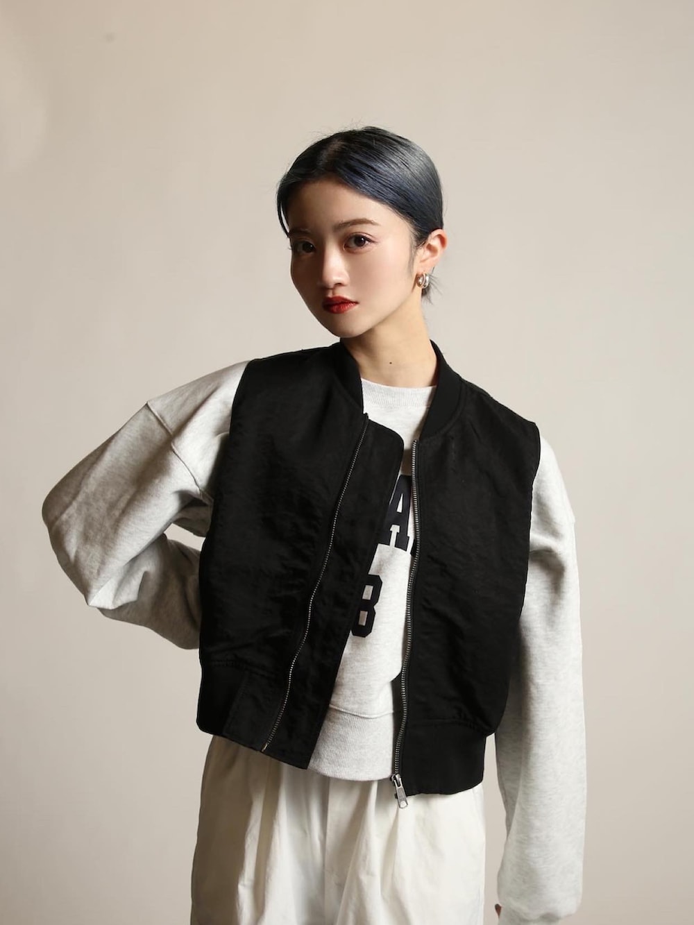 ブラック系のブーツ、ホワイト系のカーゴパンツ、ブラック系のベストを着用したレディースの冬コーディネートの2枚目の写真