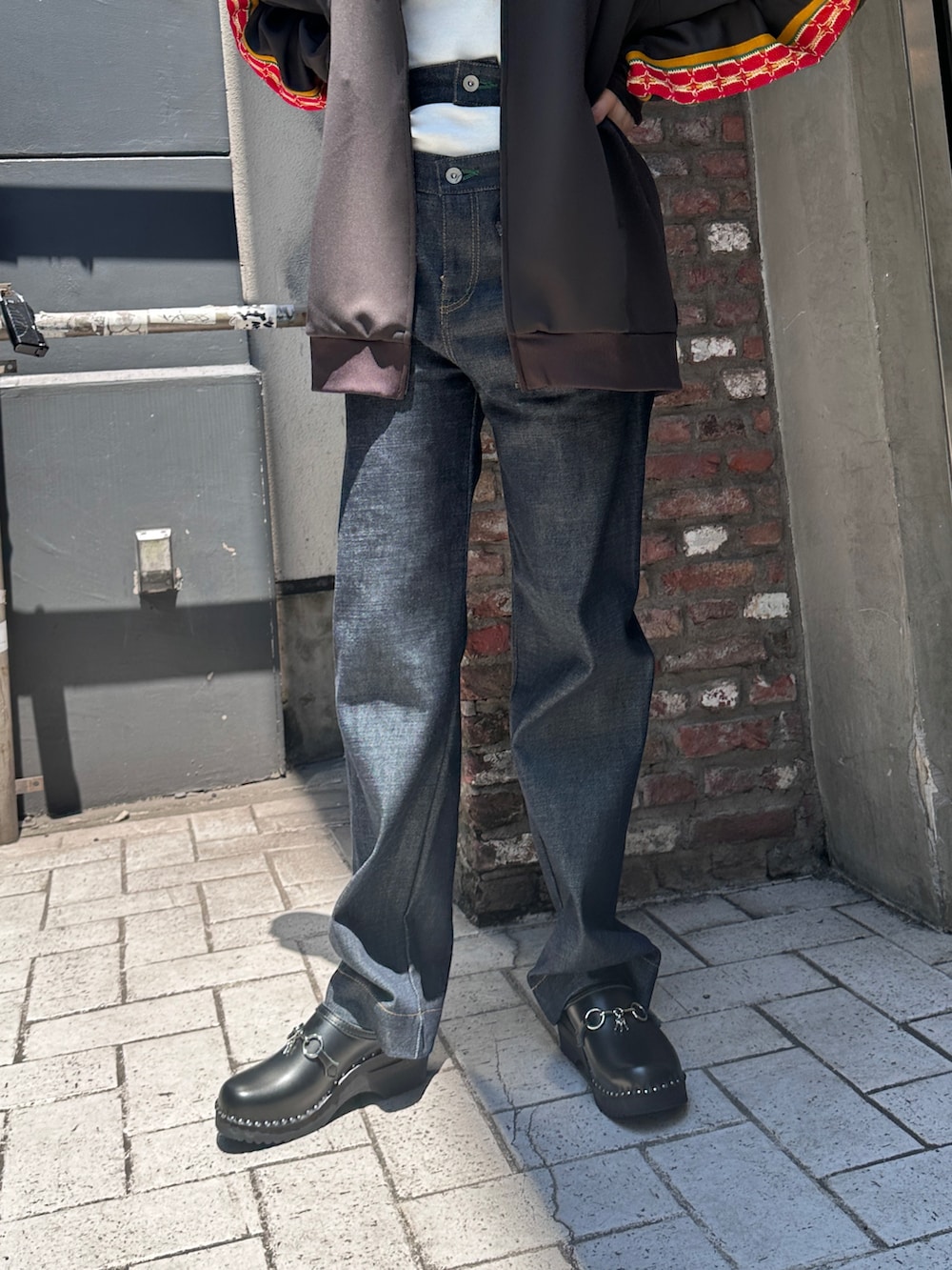 ブルー系のデニムパンツ、ブラック系のサンダル、グレー系のジャージを着用したレディースの夏コーディネートの3枚目の写真