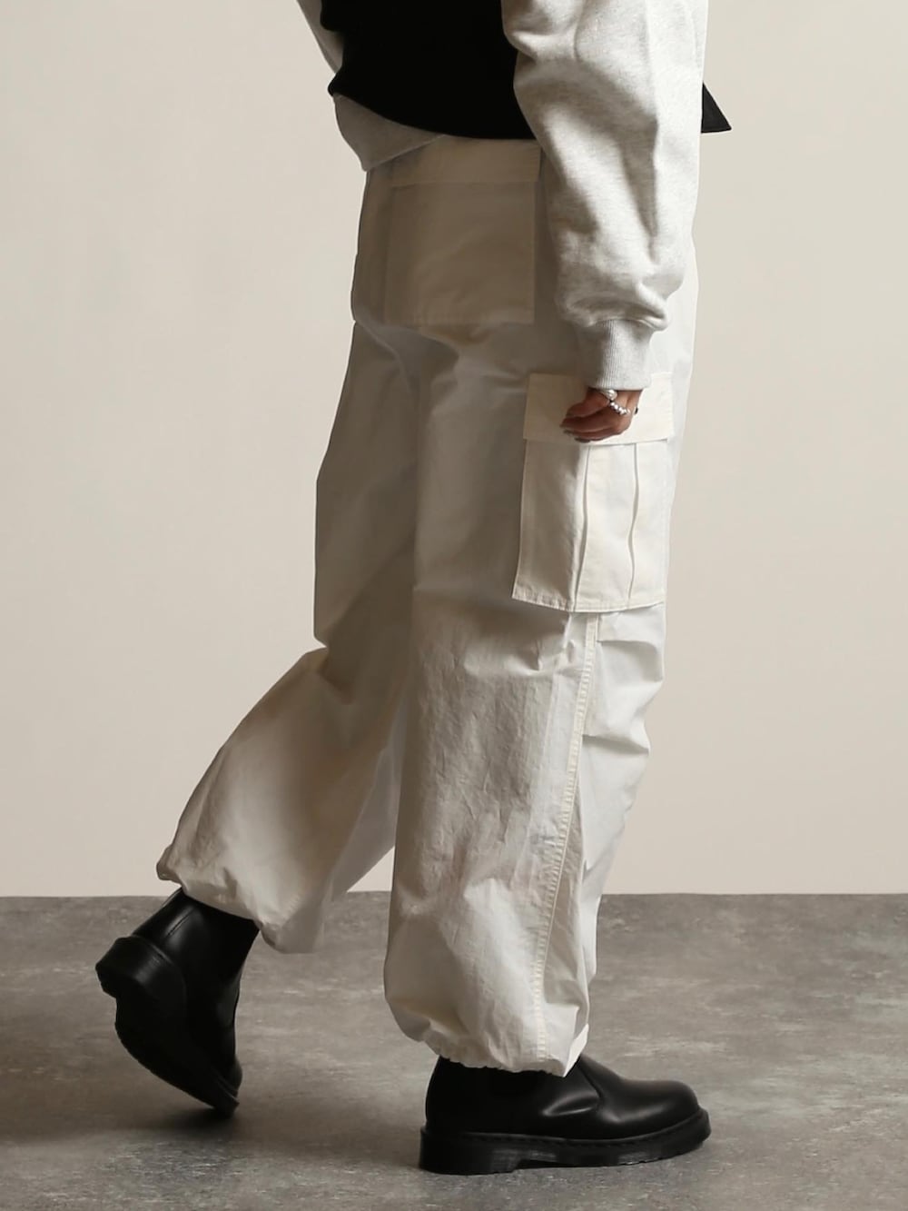 ブラック系のブーツ、ホワイト系のカーゴパンツ、ブラック系のベストを着用したレディースの冬コーディネートの3枚目の写真