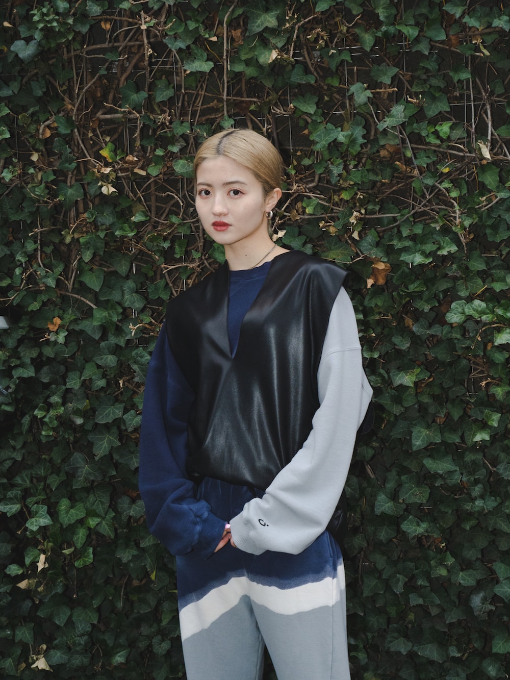 ブラック系のベスト、グレー系のスウェットパンツ、ブラック系のサンダルを着用したレディースの春コーディネートの3枚目の写真