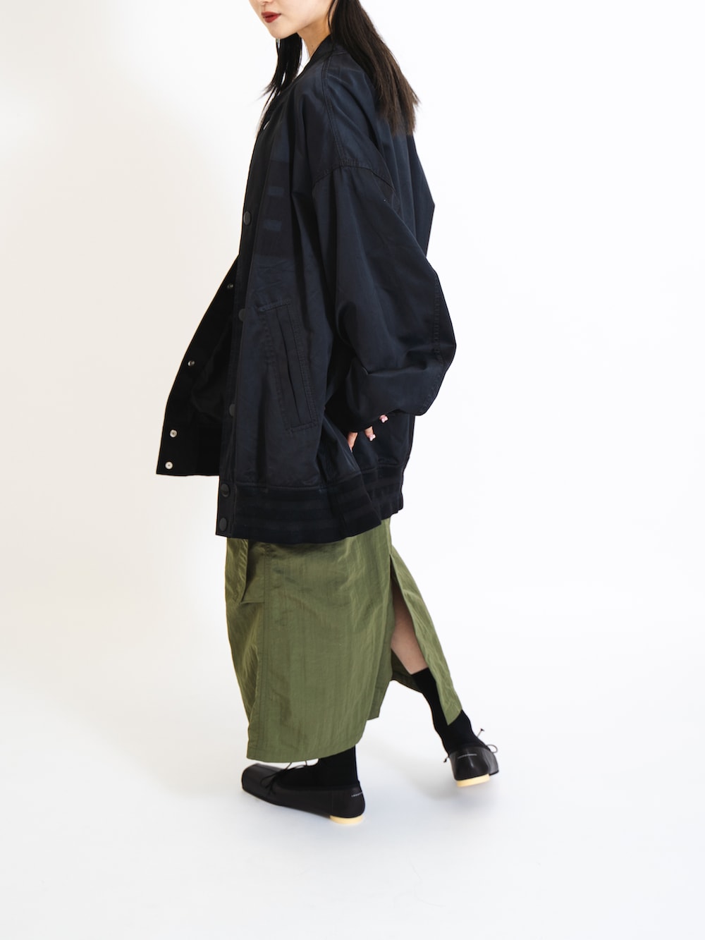 ホワイト系のキャミソール、ブラック系のMA-1、グリーン系のスカートを着用したレディースの夏コーディネートの2枚目の写真