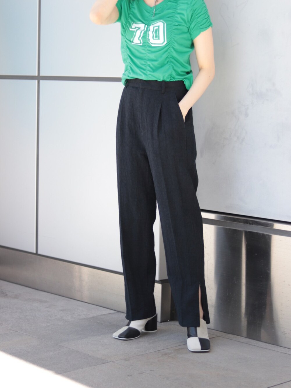 ブルー系のスラックス、グリーン系のTシャツ/カットソー、ホワイト系のサンダルを着用したレディースの夏コーディネートの3枚目の写真