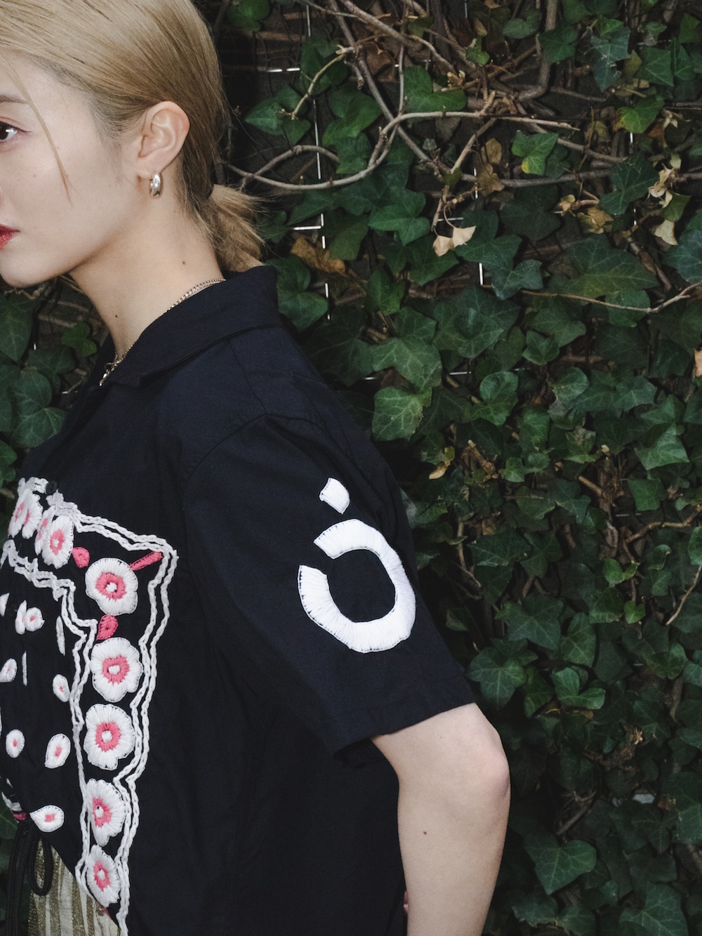 ゴールド系のスカート、ホワイト系のサンダル、ブラック系のシャツ/ブラウスを着用したレディースの春コーディネートの3枚目の写真