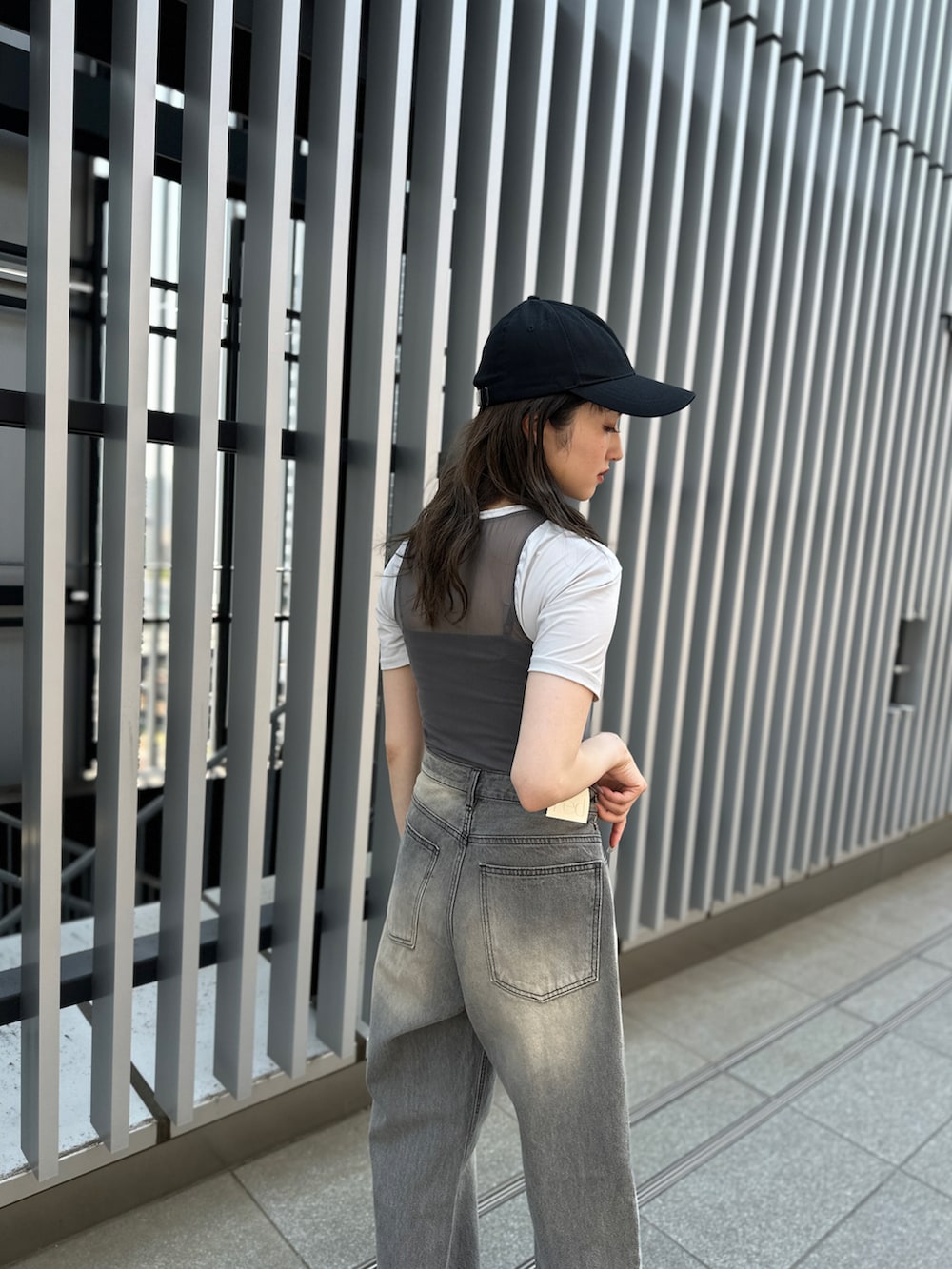 グレー系のデニムパンツ、ホワイト系のサンダル、グレー系のTシャツ/カットソーを着用したレディースの夏コーディネートの3枚目の写真