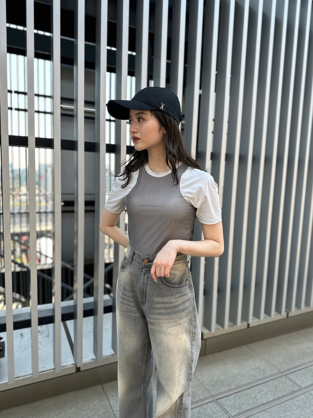 グレー系のデニムパンツ、ホワイト系のサンダル、グレー系のTシャツ/カットソーを着用したレディースの夏コーディネートの2枚目の写真