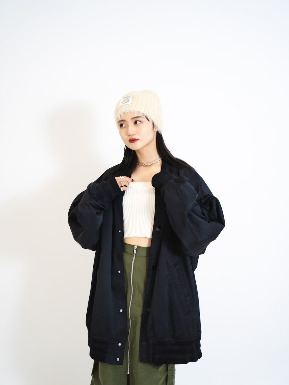 ホワイト系のキャミソール、ブラック系のMA-1、グリーン系のスカートを着用したレディースの夏コーディネートの3枚目の写真