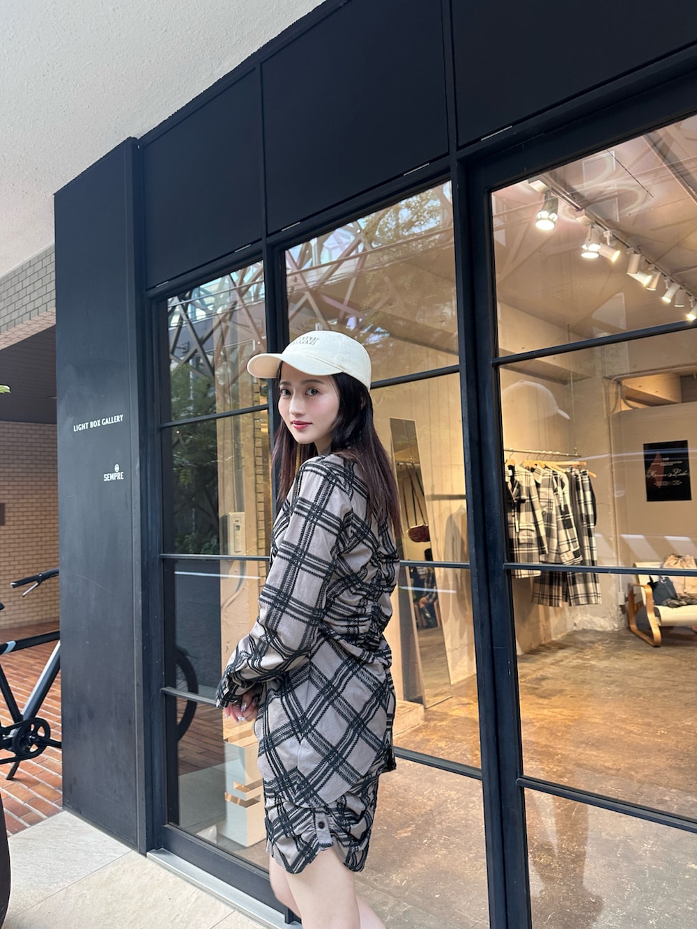 ブラウン系のシャツ/ブラウス、ブラウン系のスカート、ブラック系のスニーカーを着用したレディースの春コーディネートの2枚目の写真